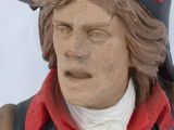statue of a man wearing a black hat and red jacket
