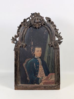 an old picture of a man in a blue coat sitting in a chair