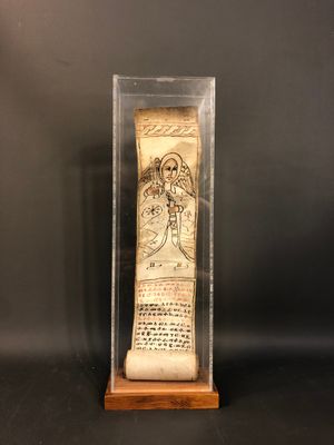 an old scroll in a glass case on a black background