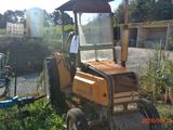 a small tractor that is parked in the grass