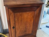 un petit meuble en bois surmonté d'une porte