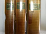 trois livres sont alignés les uns à côté des autres sur une étagère