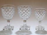 three clear glass goblets sitting on top of a white table