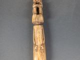 une vieille figurine en bois représentant une femme tenant un enfant dans ses bras
