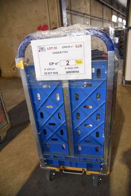 un chariot bleu sur lequel est accrochée une pancarte, dans un entrepôt