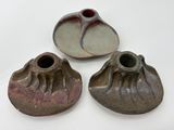 trois pièces de poterie posées sur une surface blanche