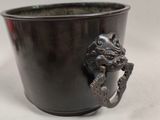 a black cup with a dragon handle on it