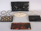 four purses and a purse chain on a white surface