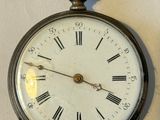clock with roman numerals displayed on white surface with shadow