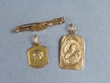 two gold - plated charms with a picture of a woman and a man