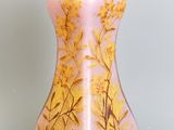 un vase rose orné d'un motif à la feuille d'or