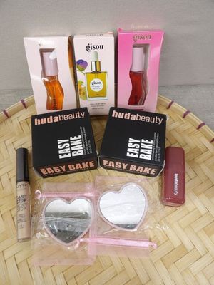 trois boîtes de maquillage et un flacon de liquide posés sur une table
