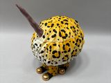 yellow and black leopard figurine sitting on a white surface