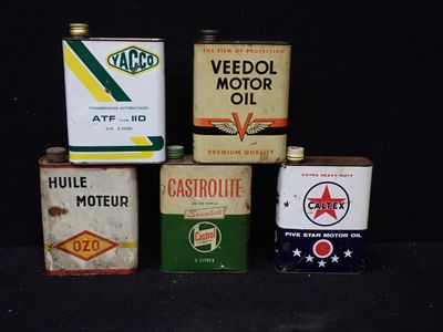 Plusieurs bidons contenant différents types d'essence sont alignés sur une surface noire