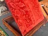 a red velvet covered box sitting on display in a glass case