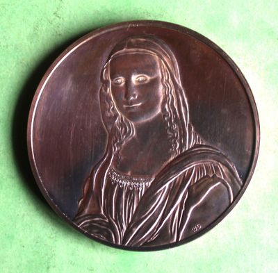 an image of a close up of a metal plaque on a green surface