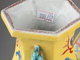 a yellow vase with a blue and red design on it