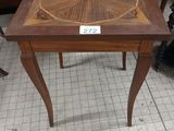 a small table with a wooden top on a tile floor