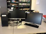 a desk with two monitors and a keyboard on it