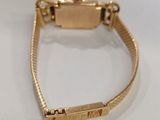 a close up of a gold watch on a white surface