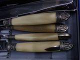 four knives and a knife holder in a box