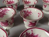 many cups and saucers sitting on a table