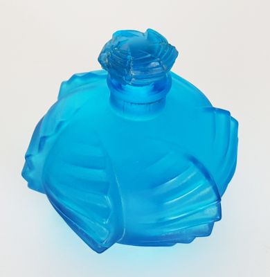 a blue glass bottle with a flower on it