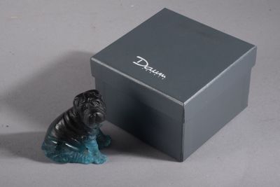 une petite figurine représentant un chien assis devant une boîte