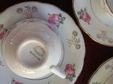 three cups and saucers are sitting on a red table cloth