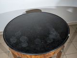 a small table with a black top on a tiled floor
