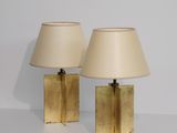 une paire de lampes de table en laiton avec des abat-jours, posées sur une table blanche