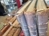 several old books are stacked on top of each other on a table
