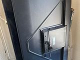 une porte noire munie d'un loquet métallique dans une pièce