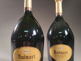 two bottles of champagne sitting next to each other on a table