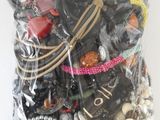 a bag of assorted jewelry on a white surface