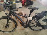 un vélo garé dans un garage, avec un sac à l'arrière