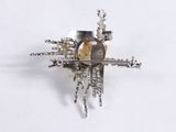 a silver brooch with a bird on top of it