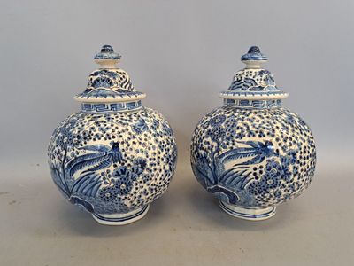 two blue and white vases sitting on top of a table