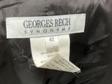 the label of a black jacket is hanging on the back of a jacket