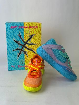 pair of colorful shoes sitting next to a box on a white surface