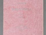 a pink book sitting on top of a table next to a cup
