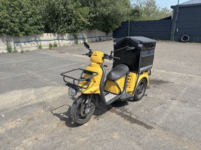 une moto jaune garée sur un parking à côté d'un immeuble