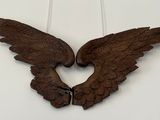 two wooden wings hanging on the wall next to each other