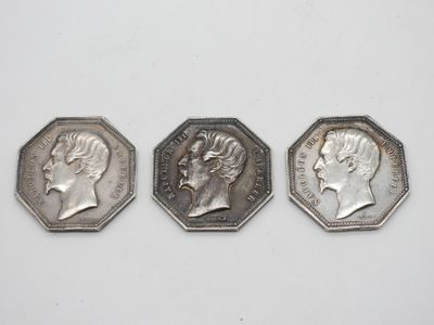 trois pièces d'argent, dont l'une représente le profil d'un homme et l'autre celui d'une femme