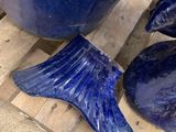 a blue vase with a fish fin on it next to a pair of shoes