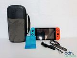 a nintendo switch lite with a case and a charger next to it