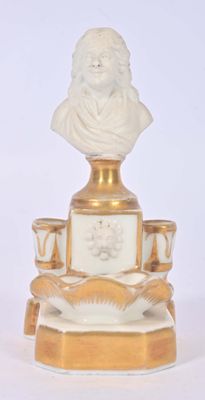 une statue représentant un homme assis sur un plateau doré et blanc