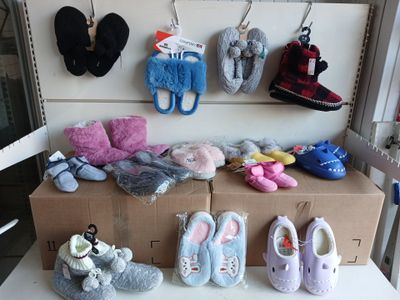 de nombreuses paires de chaussures et de mitaines sur une étagère