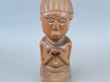 une image représentant une petite statue d'une personne portant un chapeau