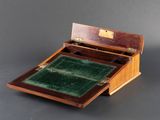 a small wooden box with a green velvet inside of it